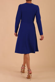 model is wearing diva catwalk moraig swing long sleeve dress with high cowl neckline and wrap skirt in cobalt blue back
