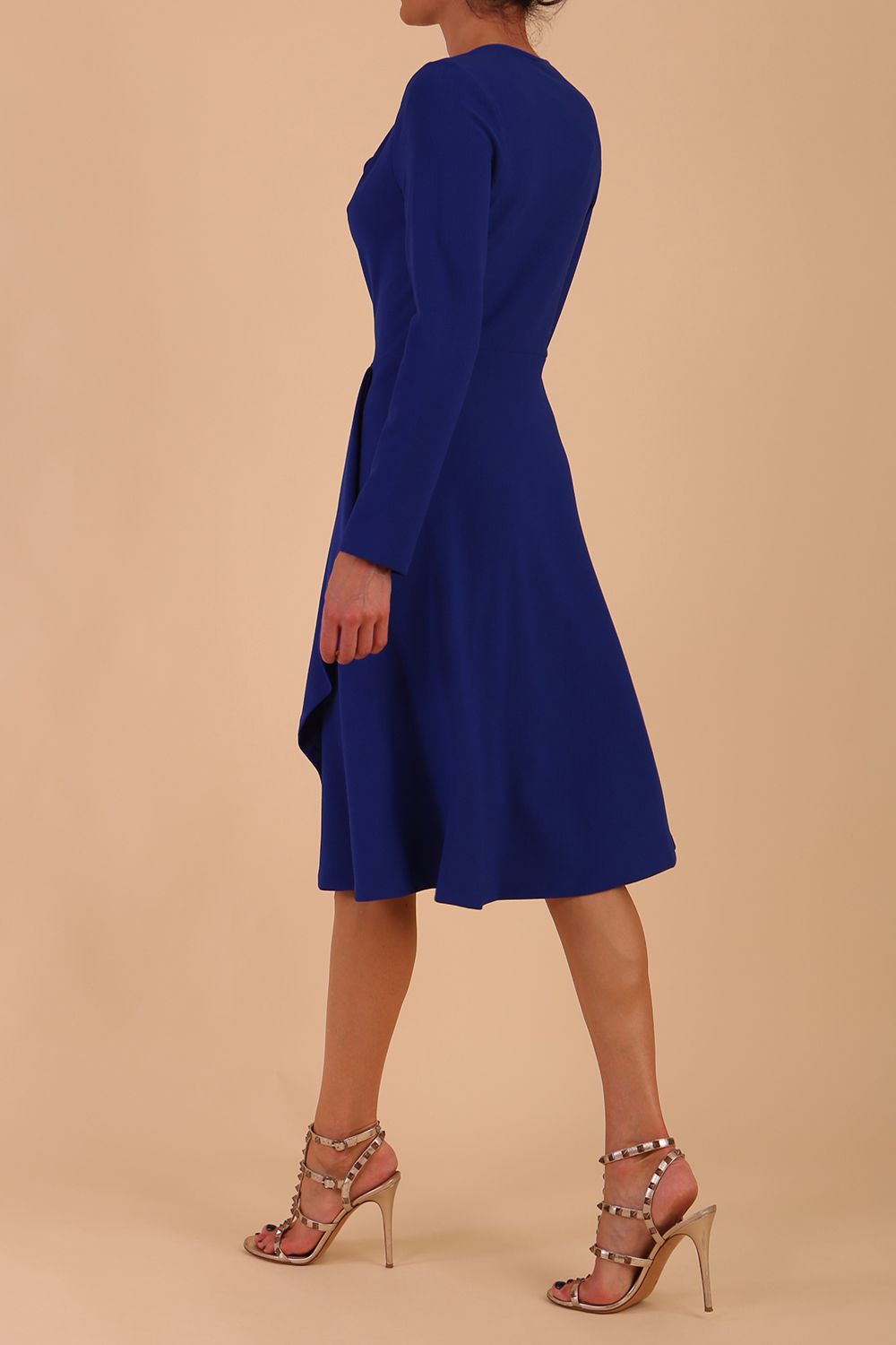 model is wearing diva catwalk moraig swing long sleeve dress with high cowl neckline and wrap skirt in cobalt blue back side