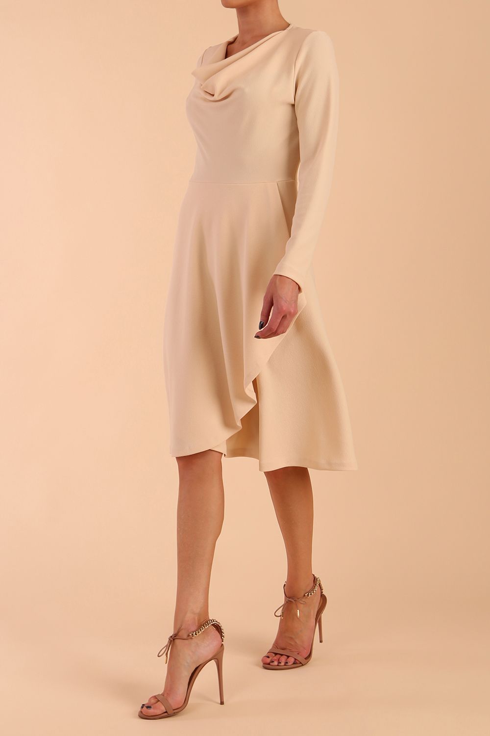 model is wearing diva catwalk moraig swing long sleeve dress with high cowl neckline and wrap skirt in beige front