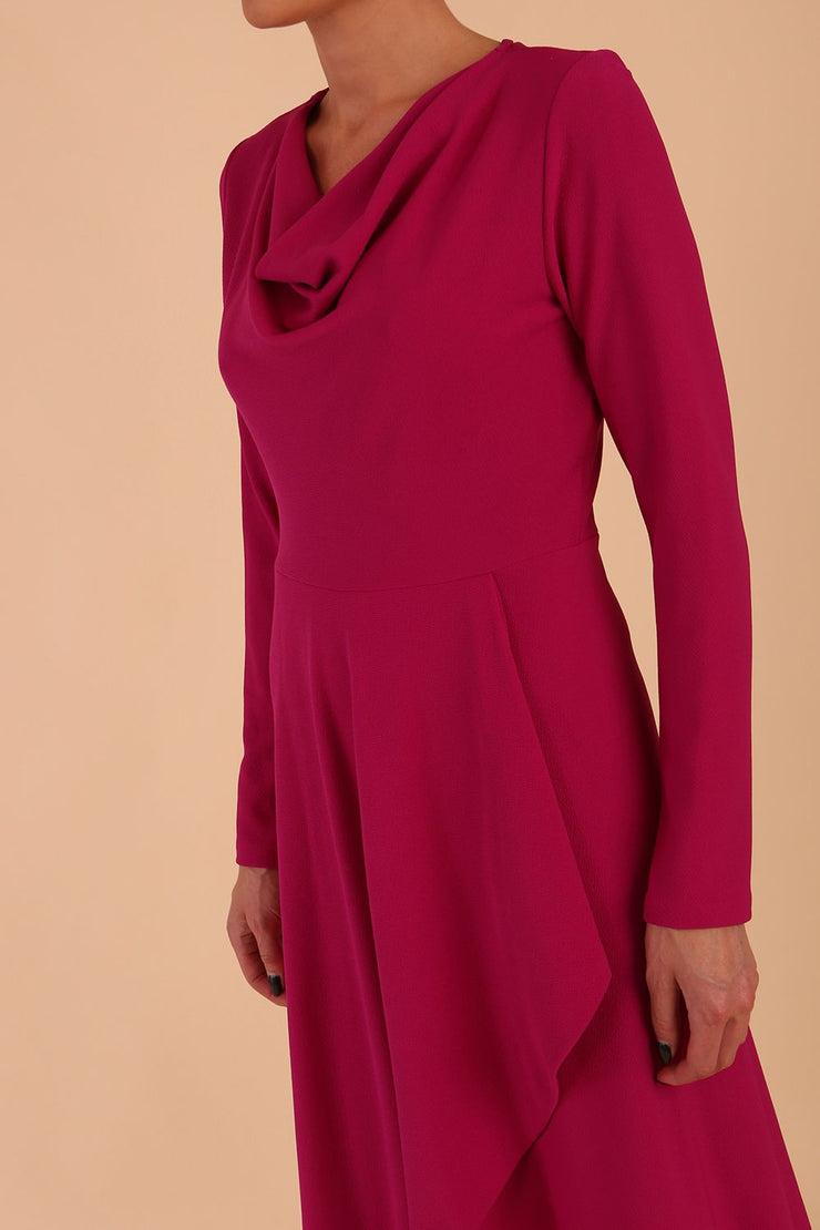 model is wearing diva catwalk moraig swing long sleeve dress with high cowl neckline and wrap skirt in beige front detail