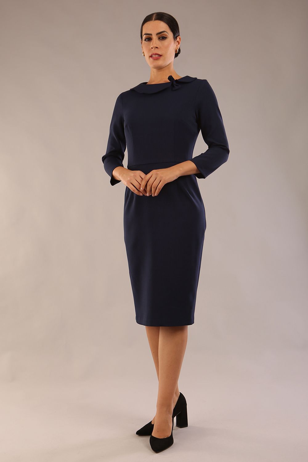 model wearing a diva catwalk  Helium 3/4 Sleeved Pencil Dress with 3/4 sleeve and knee length and bow detail on the neckline in navy blue colour front