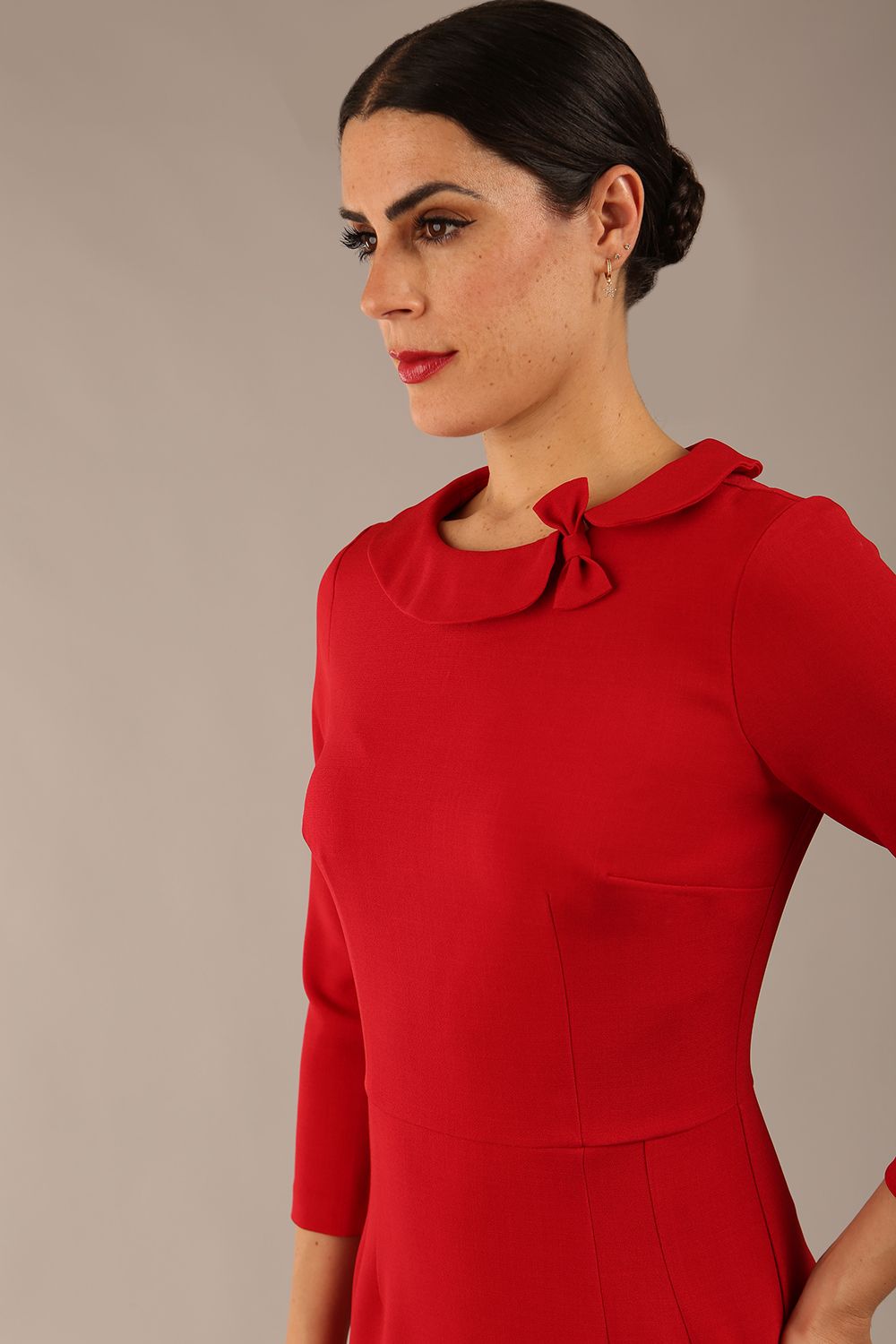 brunette model is wearing a diva catwalk  Helium 3/4 Sleeved Pencil Dress with 3/4 sleeve and knee length and bow detail on the neckline in dark red colour front close up