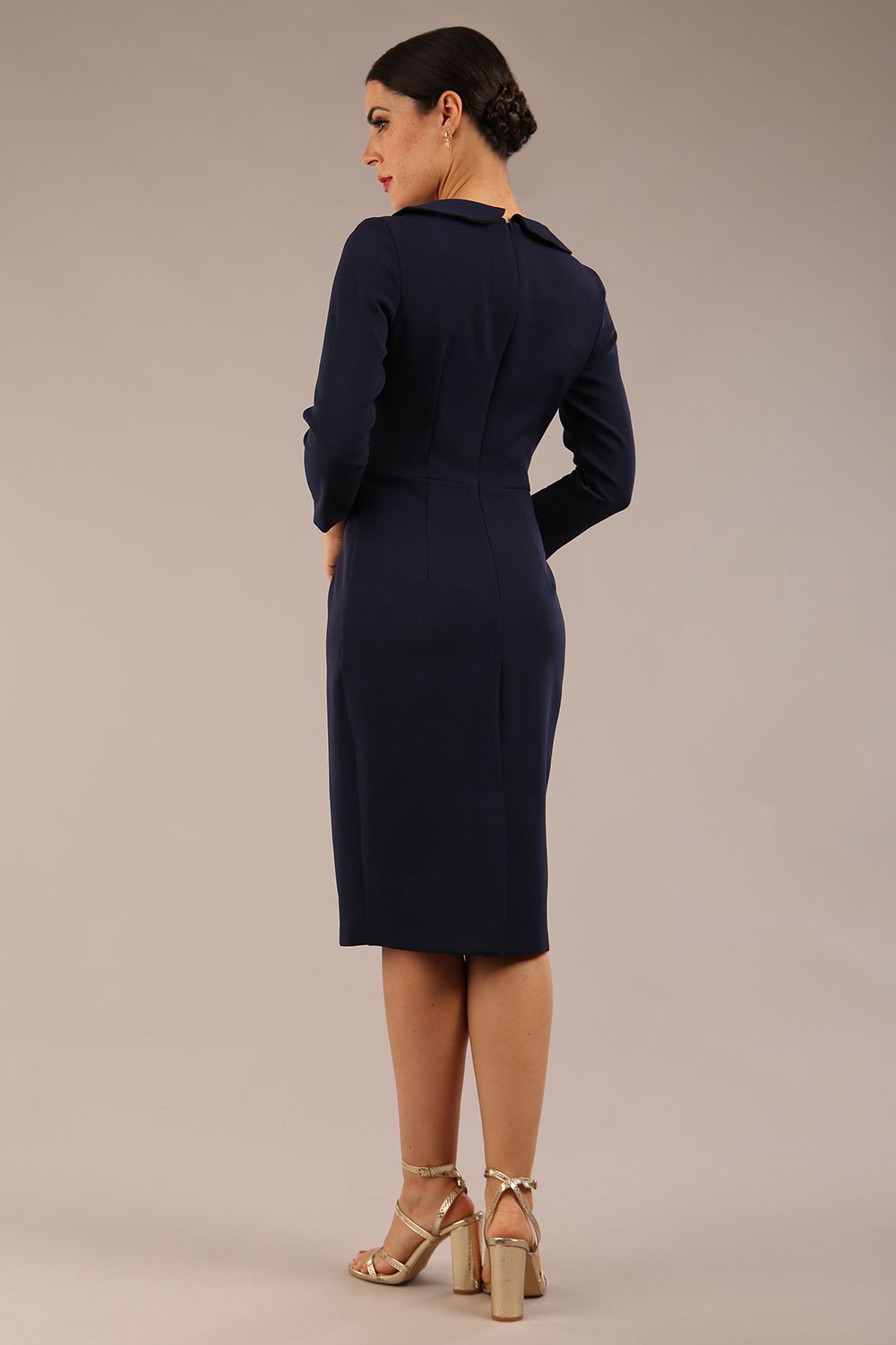 brunette model is wearing a diva catwalk  Helium 3/4 Sleeved Pencil Dress with 3/4 sleeve and knee length and bow detail on the neckline in navy blue colour back