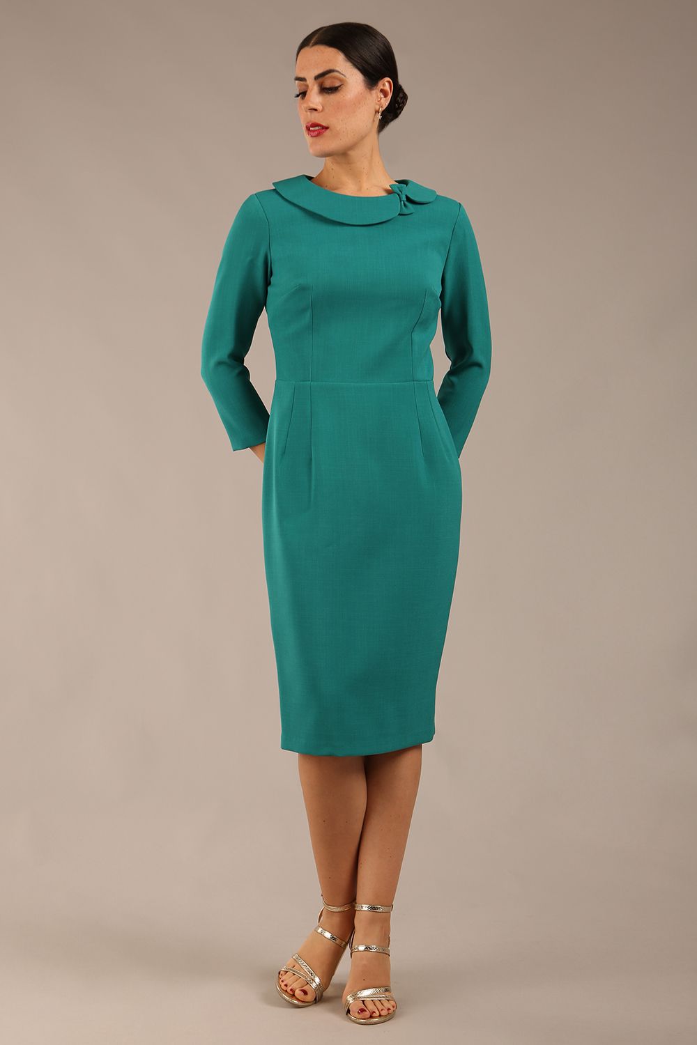 brunette model is wearing a diva catwalk  Helium 3/4 Sleeved Pencil Dress with 3/4 sleeve and knee length and bow detail on the neckline in parasailing green colour front 
