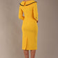 Model wearing diva catwalk Seed Elsye 3/4 Sleeve Knee Length Pencil Dress with Fold over bateau collar neckline with contrast piping and Bow feature on the left side of the bodice with decorative brooch in Daffodil Yellow colour back (Daffodil Yellow / Black Contrast)