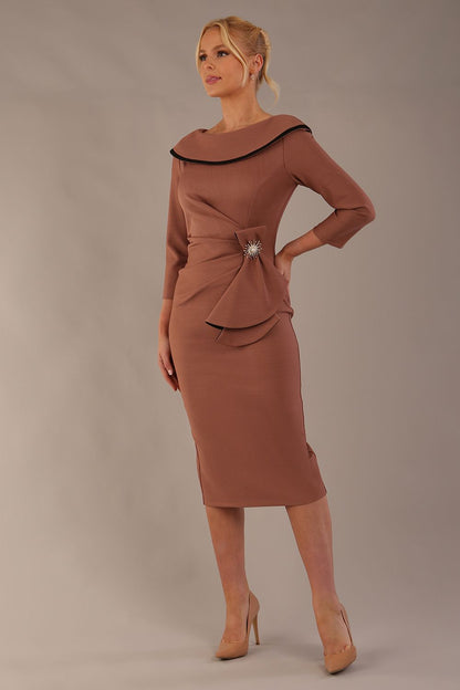Model wearing diva catwalk Seed  Elsye 3/4 Sleeve Knee Length Pencil Dress with Fold over bateau collar neckline with contrast piping and Bow feature on the left side of the bodice with decorative brooch in Acorn Brown colour front (Acorn Brown / Black Contrast)