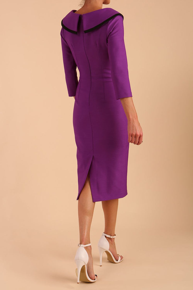 Model wearing diva catwalk Seed Elsye 3/4 Sleeve Knee Length Pencil Dress with Fold over bateau collar neckline with contrast piping and Bow feature on the left side of the bodice in Amethyst Purple colour back side