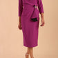 Model wearing diva catwalk Seed Elsye 3/4 Sleeve Knee Length Pencil Dress with Fold over bateau collar neckline with contrast piping and Bow feature on the left side of the bodice with decorative brooch in Dawn Purple colour front