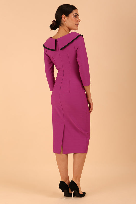 odel wearing diva catwalk Seed Elsye 3/4 Sleeve Knee Length Pencil Dress with Fold over bateau collar neckline with contrast piping and Bow feature on the left side of the bodice with decorative brooch in Dawn Purple colour back