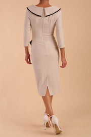 Model wearing diva catwalk Seed  Elsye 3/4 Sleeve Knee Length Pencil Dress with Fold over bateau collar neckline with contrast piping and Bow feature on the left side of the bodice in Sandy Cream colour back
