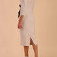 Model wearing diva catwalk Seed  Elsye 3/4 Sleeve Knee Length Pencil Dress with Fold over bateau collar neckline with contrast piping and Bow feature on the left side of the bodice in Sandy Cream colour back side