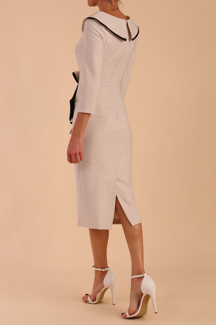 Model wearing diva catwalk Seed  Elsye 3/4 Sleeve Knee Length Pencil Dress with Fold over bateau collar neckline with contrast piping and Bow feature on the left side of the bodice in Sandy Cream colour back side