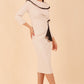 Model wearing diva catwalk Seed Elsye 3/4 Sleeve Knee Length Pencil Dress with Fold over bateau collar neckline with contrast piping and Bow feature on the left side of the bodice in Sandy Cream colour front side