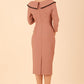 Model wearing diva catwalk Seed Elsye 3/4 Sleeve Knee Length Pencil Dress with Fold over bateau collar neckline with contrast piping and Bow feature on the left side of the bodice with decorative brooch in Acorn Brown colour back