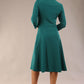 model is wearing diva catwalk palmerston vintage style a-line dress with sleeves and high neck with a slit in pacific green colour back