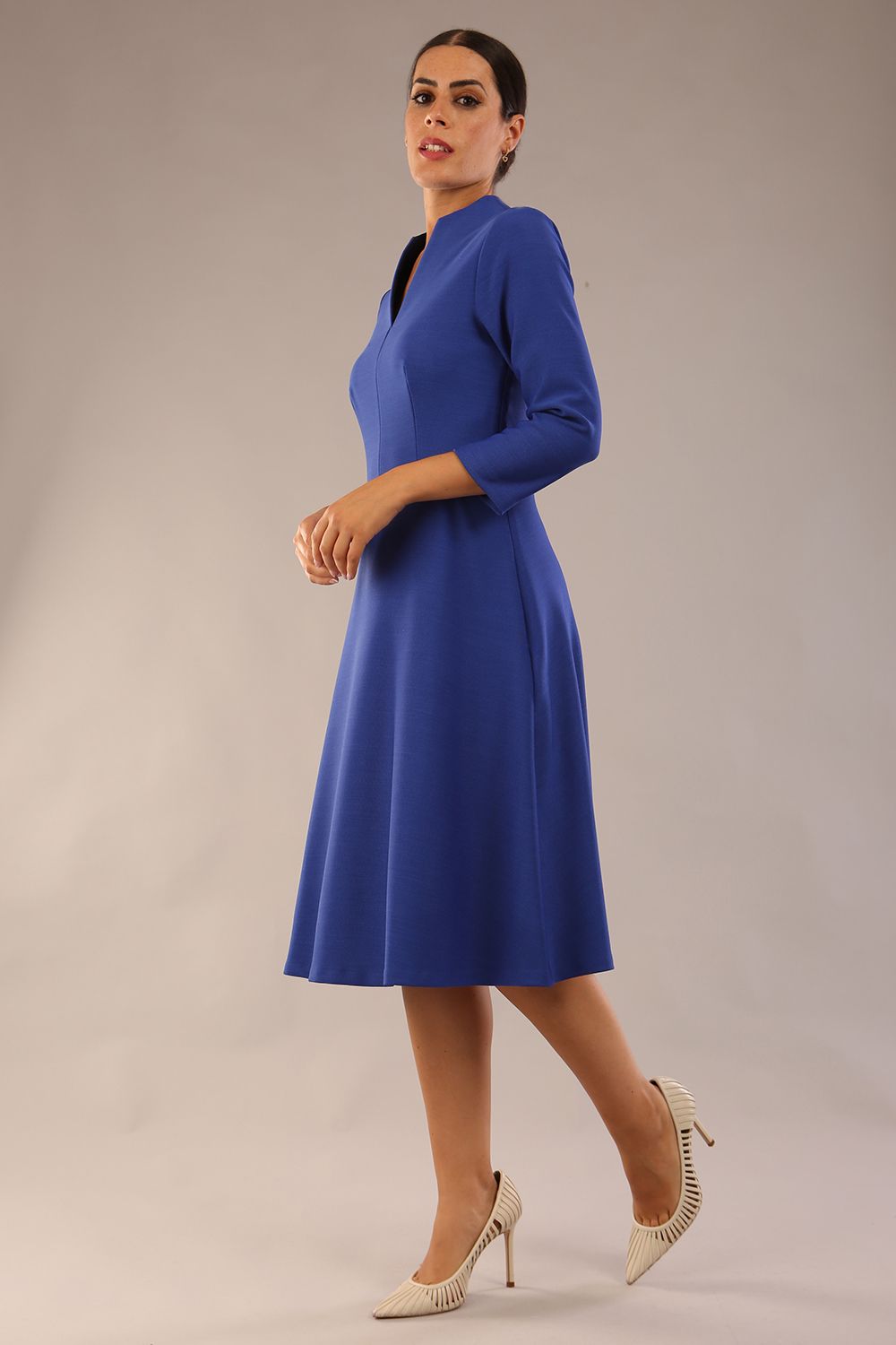 model is wearing diva catwalk palmerston vintage style a-line dress with sleeves and high neck with a slit in monaco blue colour front