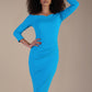 Model wearing diva catwalk Trixie dress against a beige background in (Turquoise)
