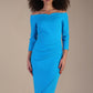 Model wearing diva catwalk Trixie dress against a beige background in (Turquoise)