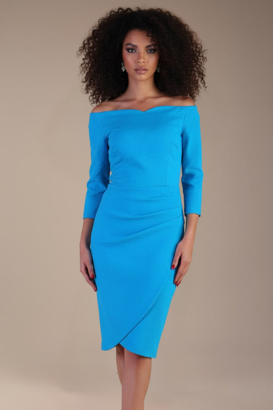 Model wearing diva catwalk Trixie dress against a beige background in (Turquoise)