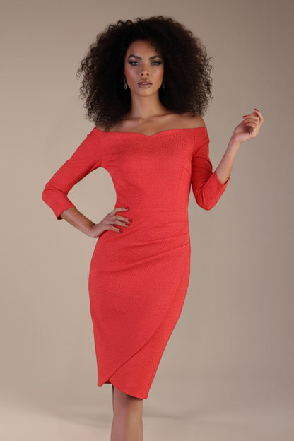 Model wearing diva catwalk Trixie dress against a beige background in (Salmon Red)