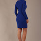 model wearing a diva catwalk lydia long sleeved pleated Mini Dress from Diva Catwalk in cobalt blue in high heal shoes against a beige background back view