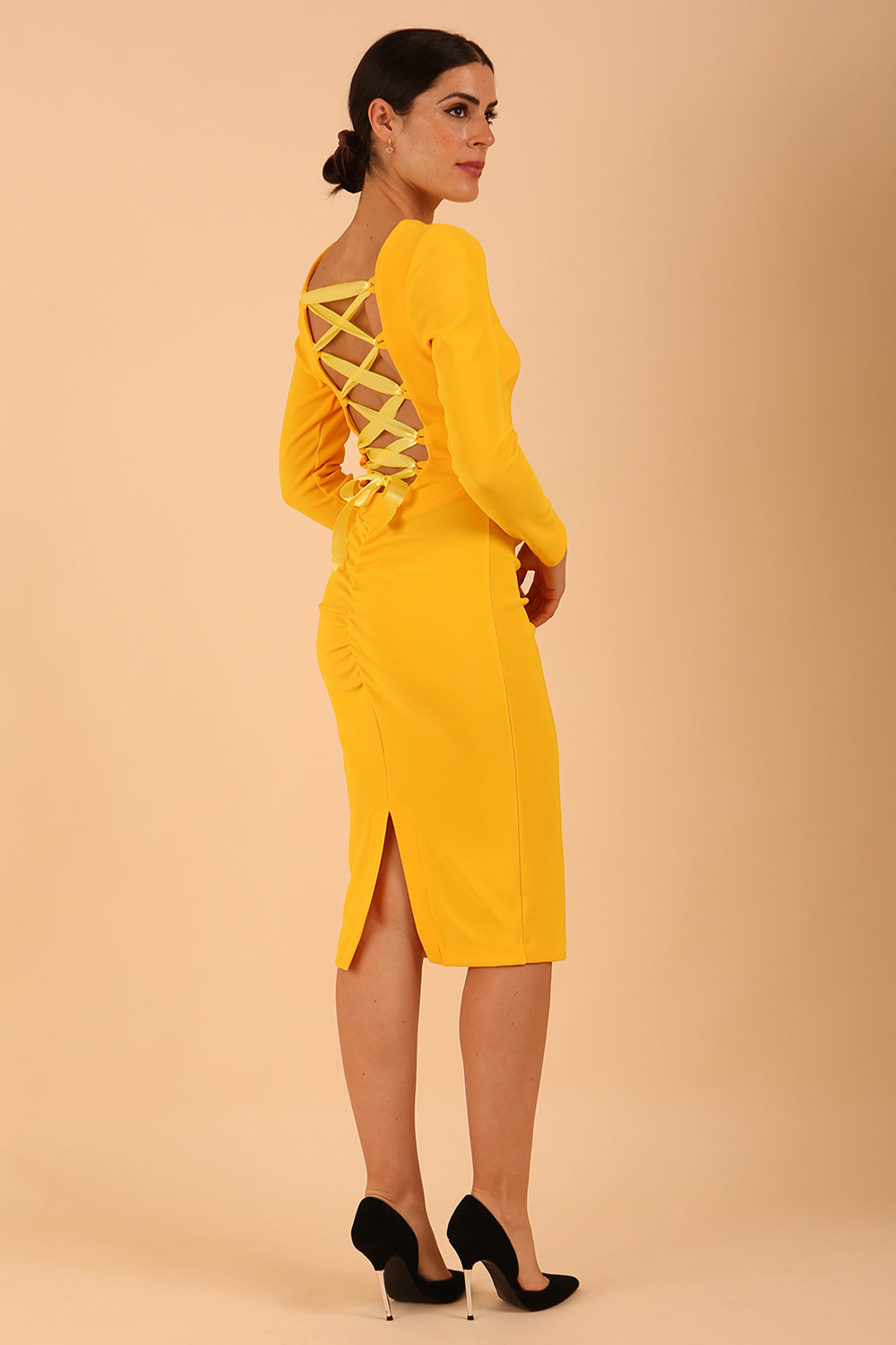 model wearing a diva catwalk Zoey Sleeved Pencil Dress ribbon back with long sleeves and rushed details front and back in Sunshine Yellow colour