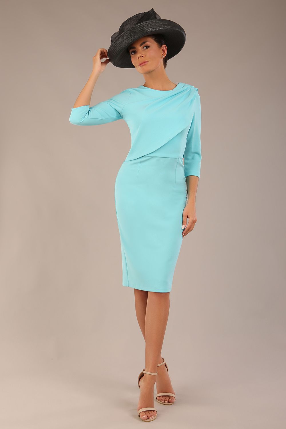 brunette model is wearing a diva catwalk Frieth Gathered Shoulder Dress 3/4 sleeves knee length with shoulder detail in turquoise colour front image with a hat