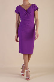 Model is wearing Brooke Cap Sleeve Pencil Dress in Couture Stretch Fabric with V Neckline and Hip Pleating in Amethyst Purple front