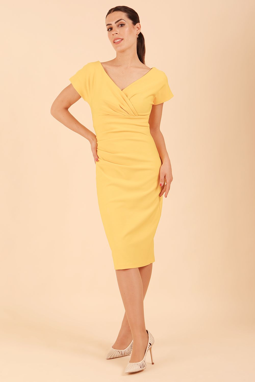 Model is wearing Brooke Cap Sleeve Pencil Dress in Couture Stretch Fabric with V Neckline and Hip Pleating in Daffodil Yellow front