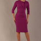 The model is wearing a diva catwalk Juliette 3/4 Sleeve Knee Length dress with bow detail in hollyhock purple colour against a plain background