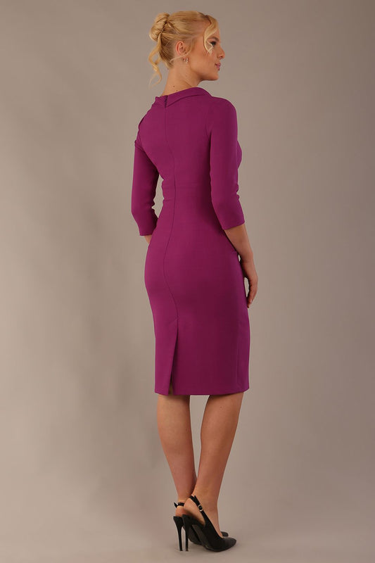 The model is wearing a diva catwalk Juliette 3/4 Sleeve Knee Length dress with bow detail in hollyhock purple colour against a plain background back view