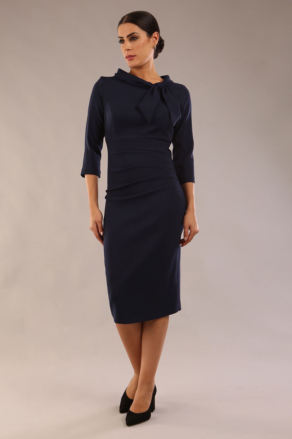 Model is wearing a diva catwalk Juliette 3/4 Sleeve Knee Length dress with bow detail in Navy Blue front