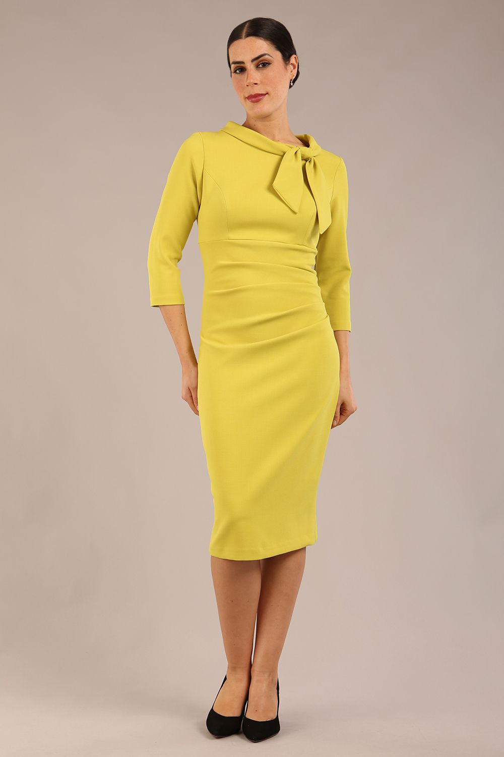 Model is wearing a diva catwalk Juliette 3/4 Sleeve Knee Length dress with bow detail in citrus green colour