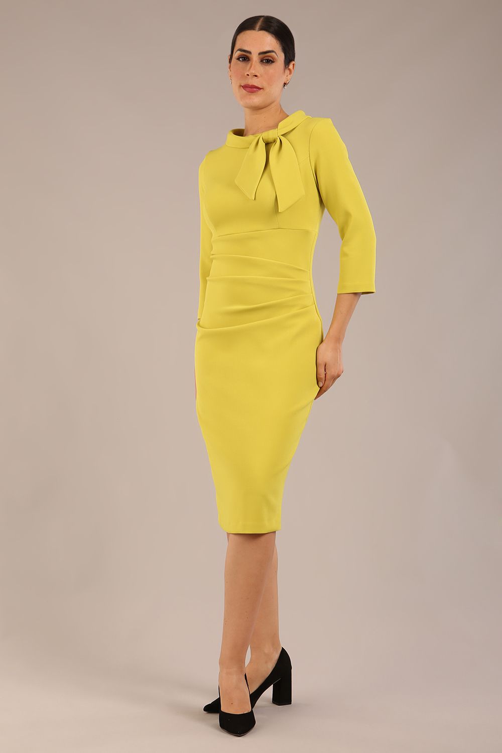 Model is wearing a diva catwalk Juliette 3/4 Sleeve Knee Length dress with bow detail in citrus green colour