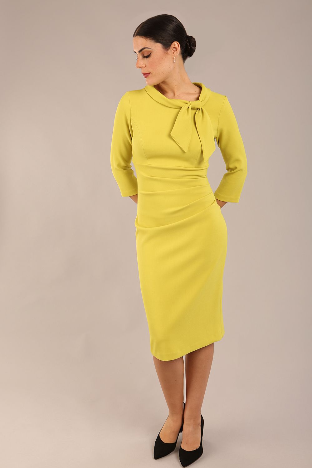 Model is wearing a diva catwalk Juliette 3/4 Sleeve Knee Length dress with bow detail in citrus green colour