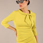 Model is wearing a diva catwalk Juliette 3/4 Sleeve Knee Length dress with bow detail in citrus green colour