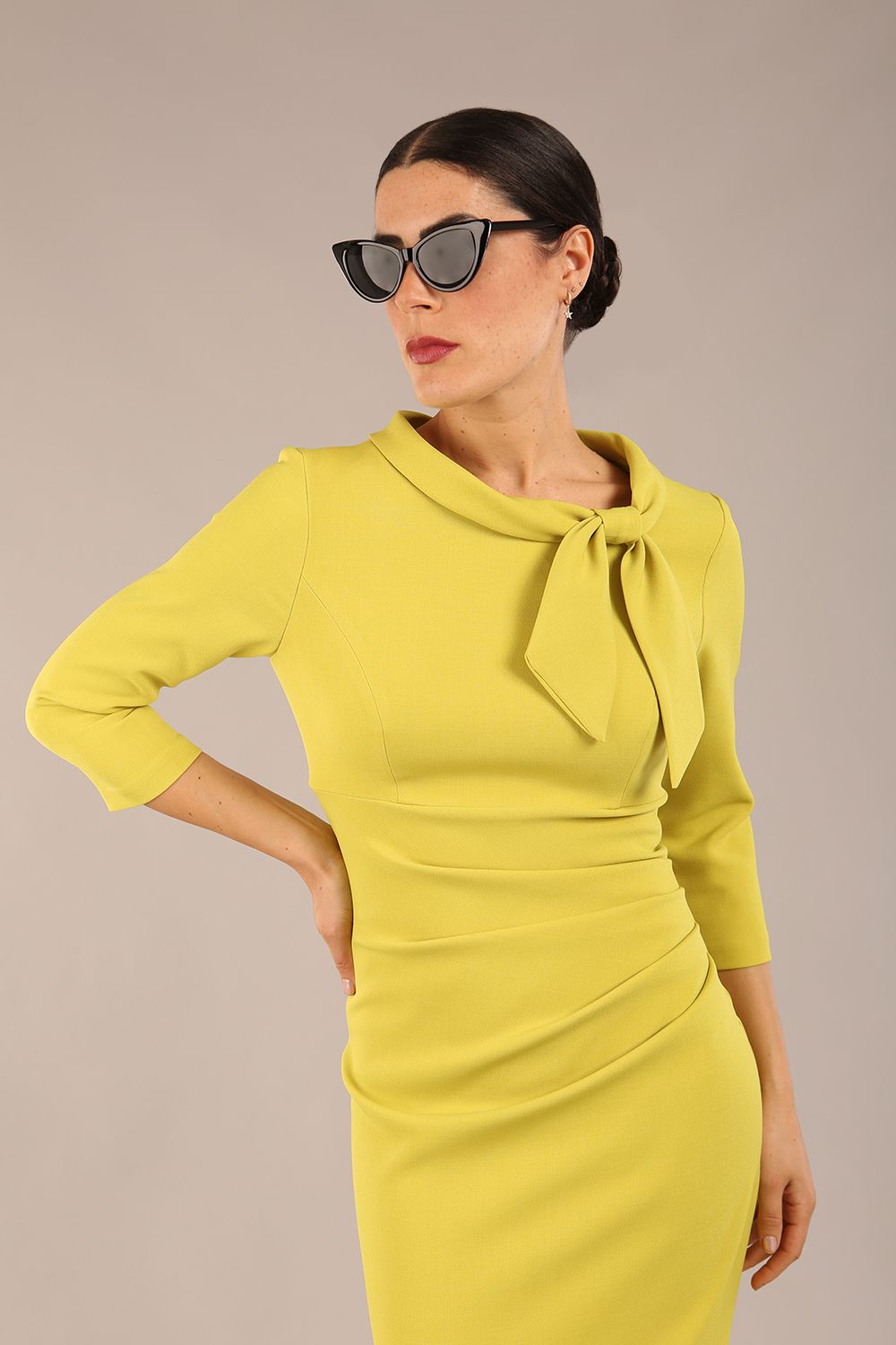 Model is wearing a diva catwalk Juliette 3/4 Sleeve Knee Length dress with bow detail in citrus green colour