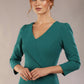 Woman wearing the SEED Cyrus asymmetric lapel pencil dress against a neutral background (Pacific Green)