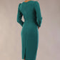 Woman wearing a  SEED Cyrus pencil dress in pacific green, showing the tailored fit. against a beige background Back view (Pacific Green)