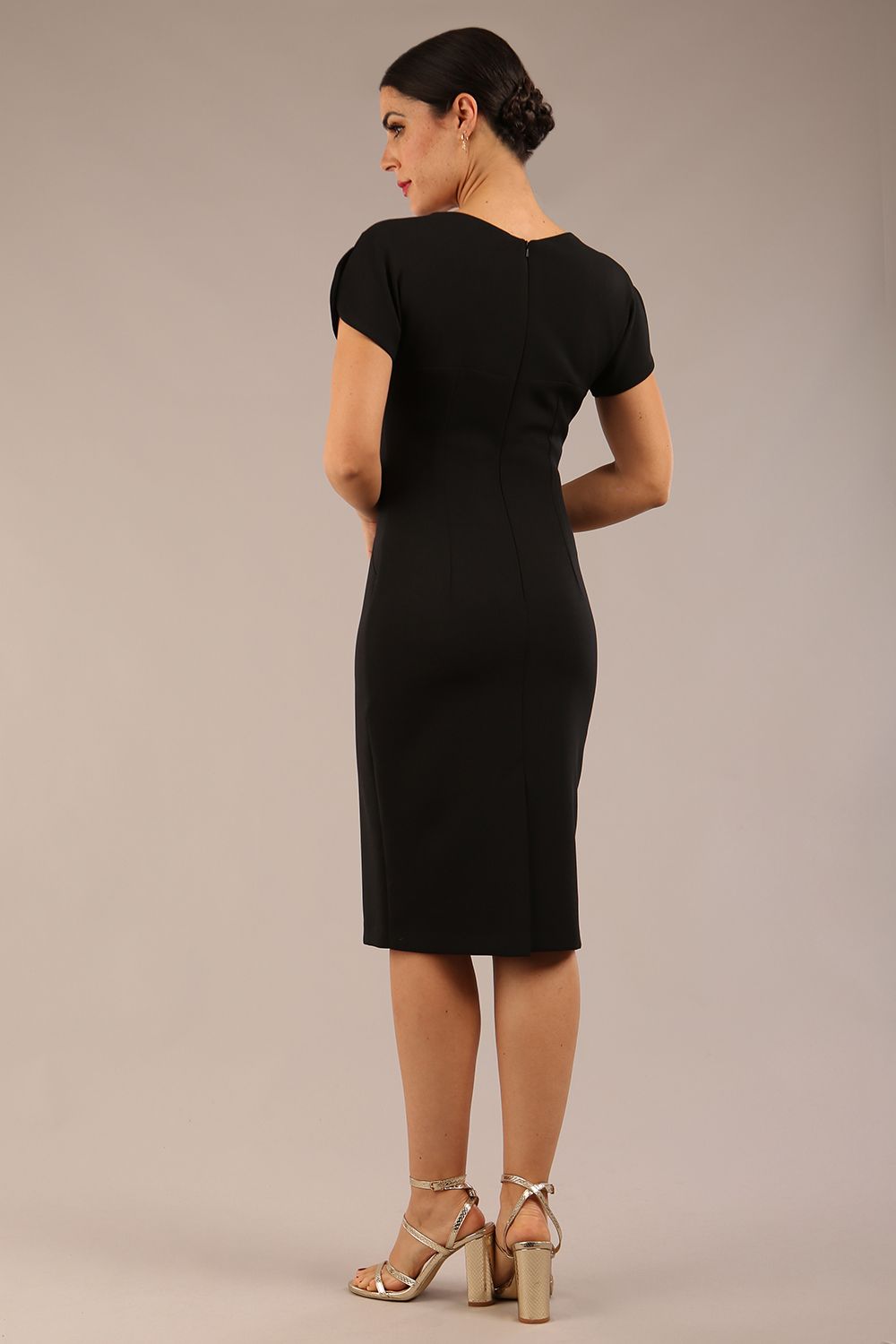 brunette Model wearing a diva catwalk Sheena Short Sleeve with an open split Knee Length Pencil Dress with Diamond Neckline in Black colour back