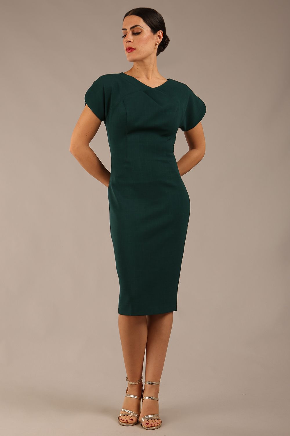 brunette Model wearing a diva catwalk Sheena Short Sleeve with an open split Knee Length Pencil Dress with Diamond Neckline in Forest Green colour front