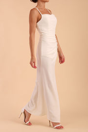 Model wearing Sabrina Maxi Dress with square neckline, sleeveless style, pleating details and side open split, open back in Ivory Cream front side