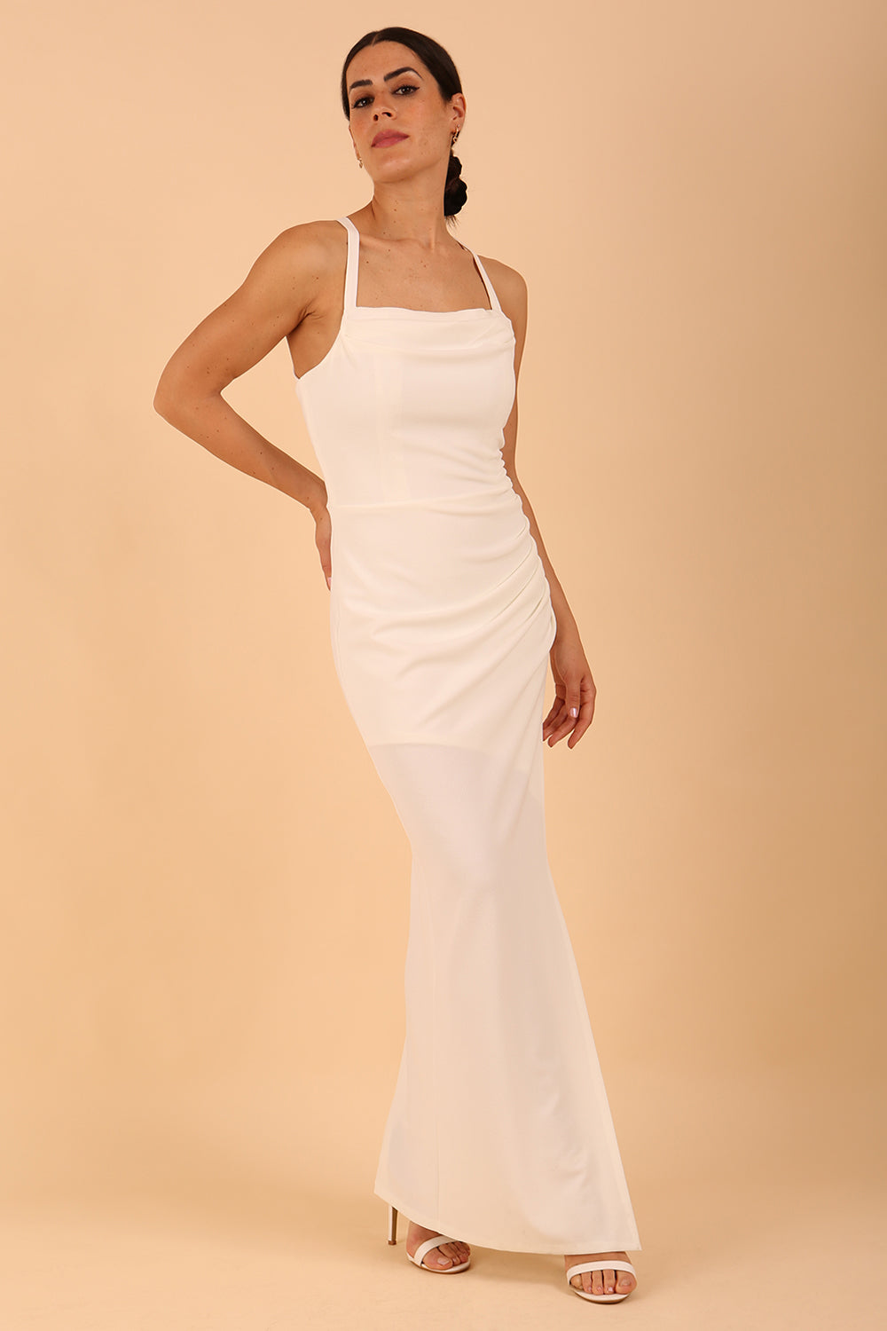 Model wearing Sabrina Maxi Dress with square neckline, sleeveless style, pleating details and side open split, open back in Ivory Cream
