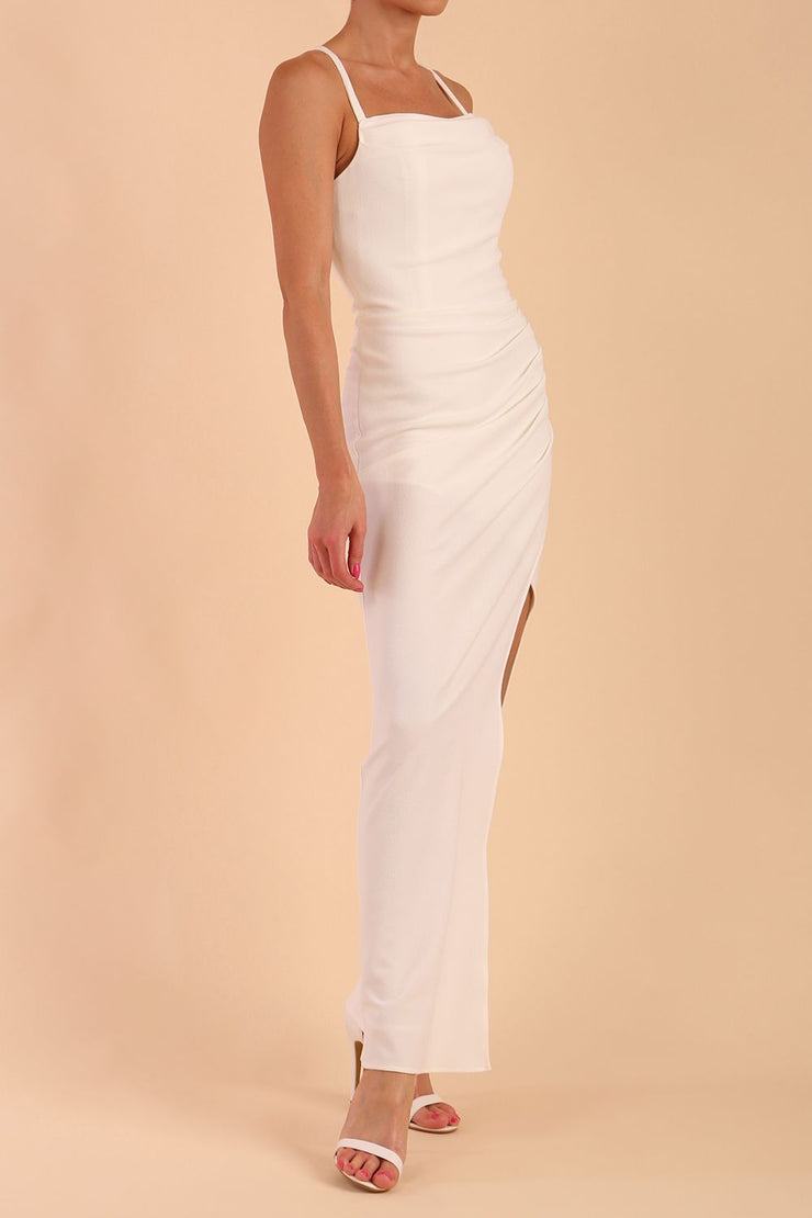 Model wearing Sabrina Maxi Dress with square neckline, sleeveless style, pleating details and side open split, open back in Ivory Cream front side
