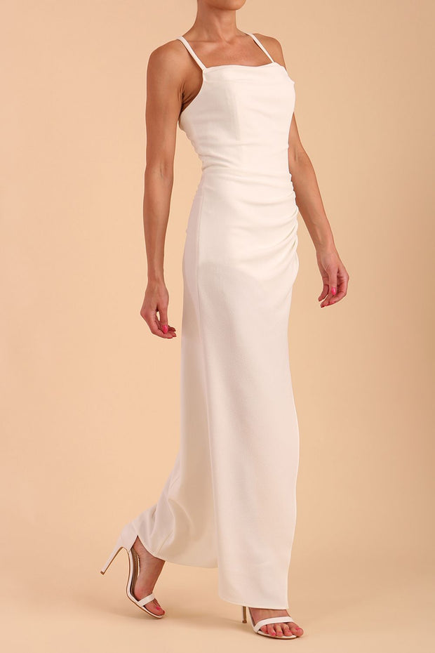 Model wearing Sabrina Maxi Dress with square neckline, sleeveless style, pleating details and side open split, open back in Ivory Cream front side