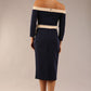 Model wearing a diva catwalk Brittany Off Shoulder Bow detail Pencil Dress with 3/4 sleeves and knee length in Navy Blue and Sandshell Beige colour front side