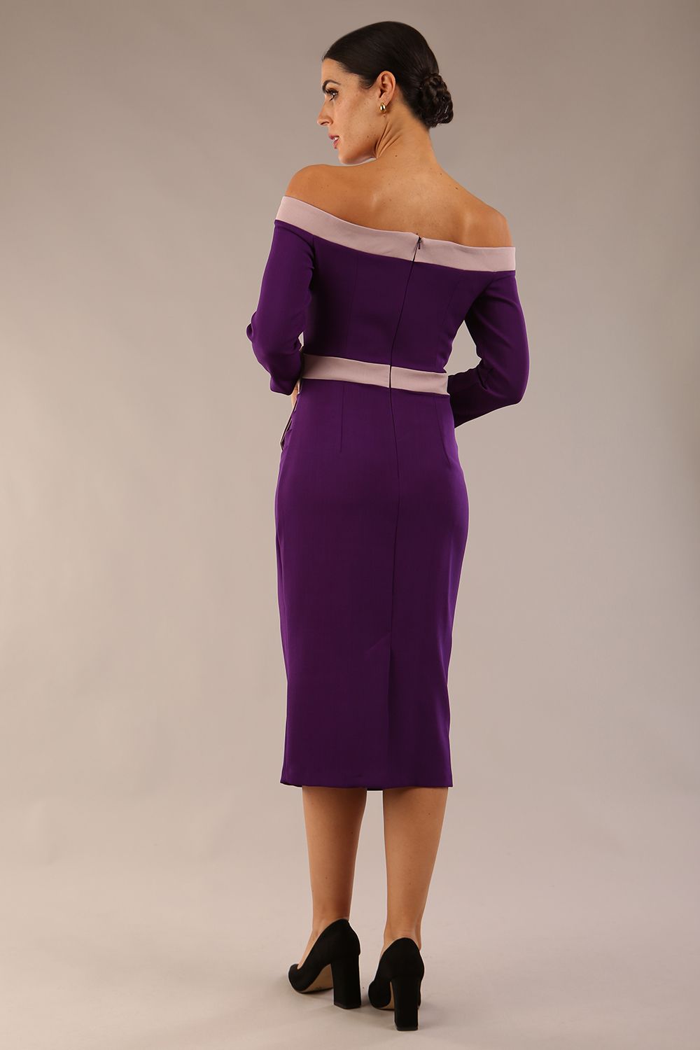 Model wearing a diva catwalk Brittany Off Shoulder Bow detail Pencil Dress with 3/4 sleeves and knee length in Deep Purple and Thunder Bird colour