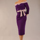 Model wearing a diva catwalk Brittany Off Shoulder Bow detail Pencil Dress with 3/4 sleeves and knee length in Deep Purple and Thunder Bird colour