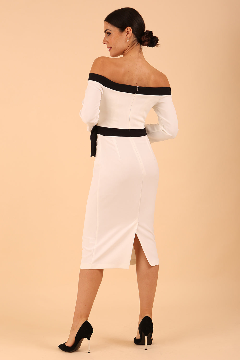 Model wearing a diva catwalk Brittany Off Shoulder Bow detail Pencil Dress with 3/4 sleeves and knee length in Ivory and Black colour back