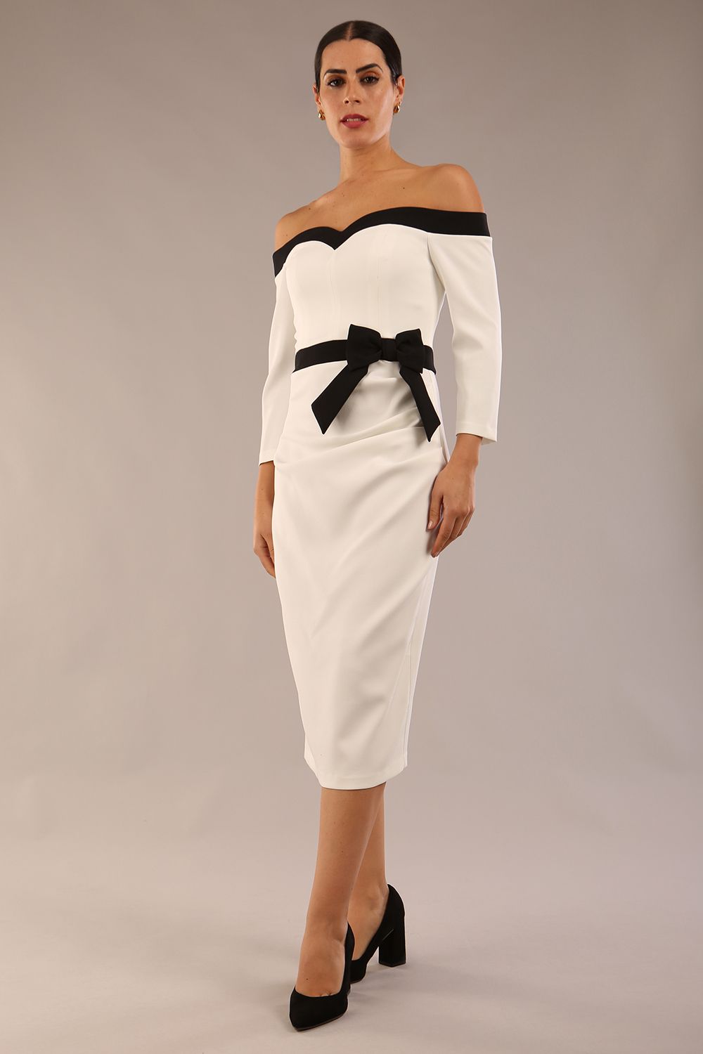 Model wearing a diva catwalk Brittany Off Shoulder Bow detail Pencil Dress with 3/4 sleeves and knee length in Ivory and Black colour